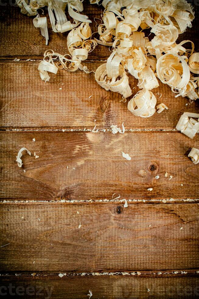 Wooden shavings on the table. On a wooden background. photo