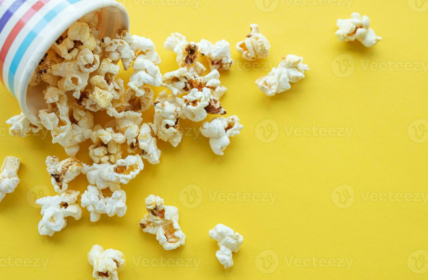 Popcorn bucket on yellow background photo
