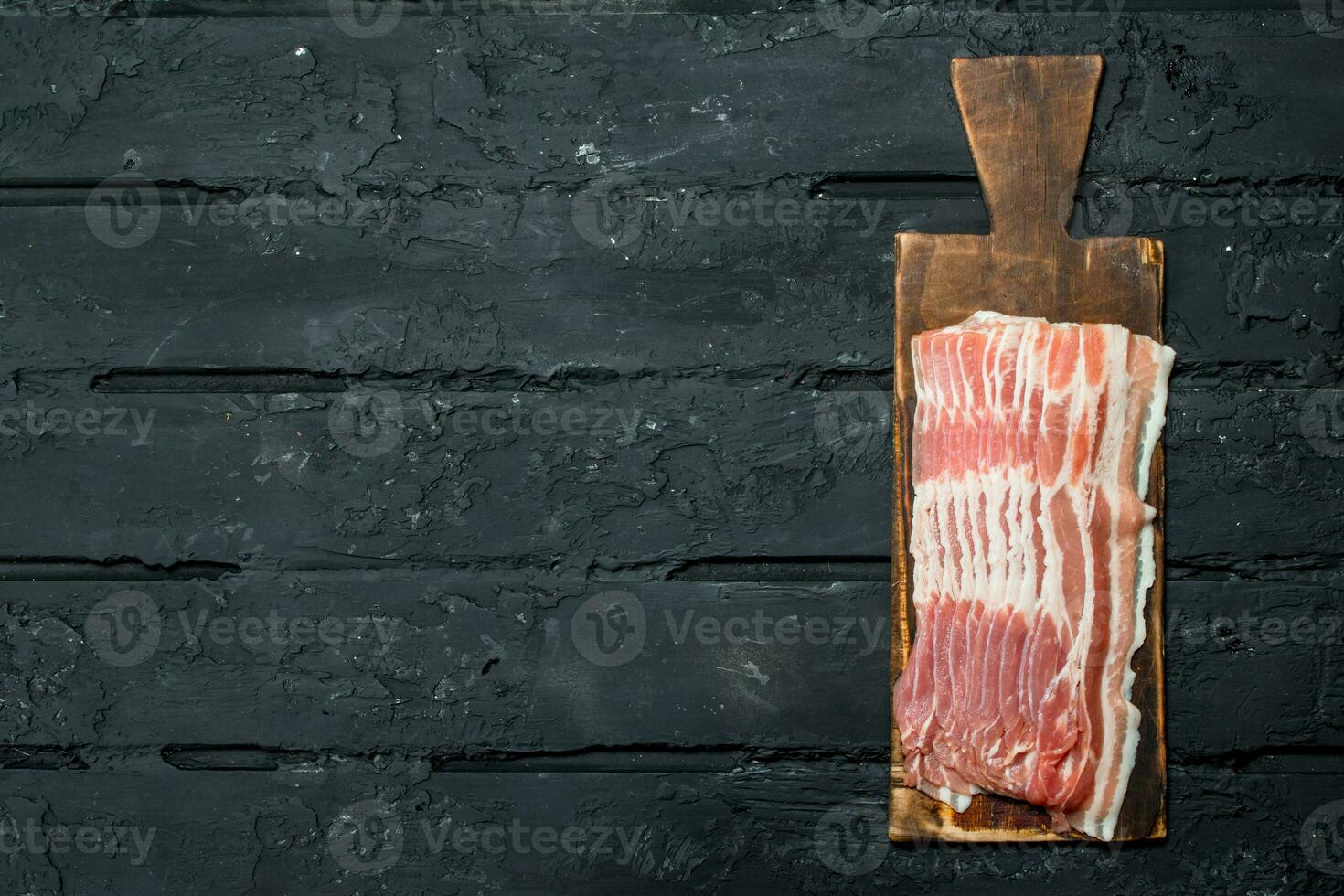 Raw bacon on a cutting Board. photo