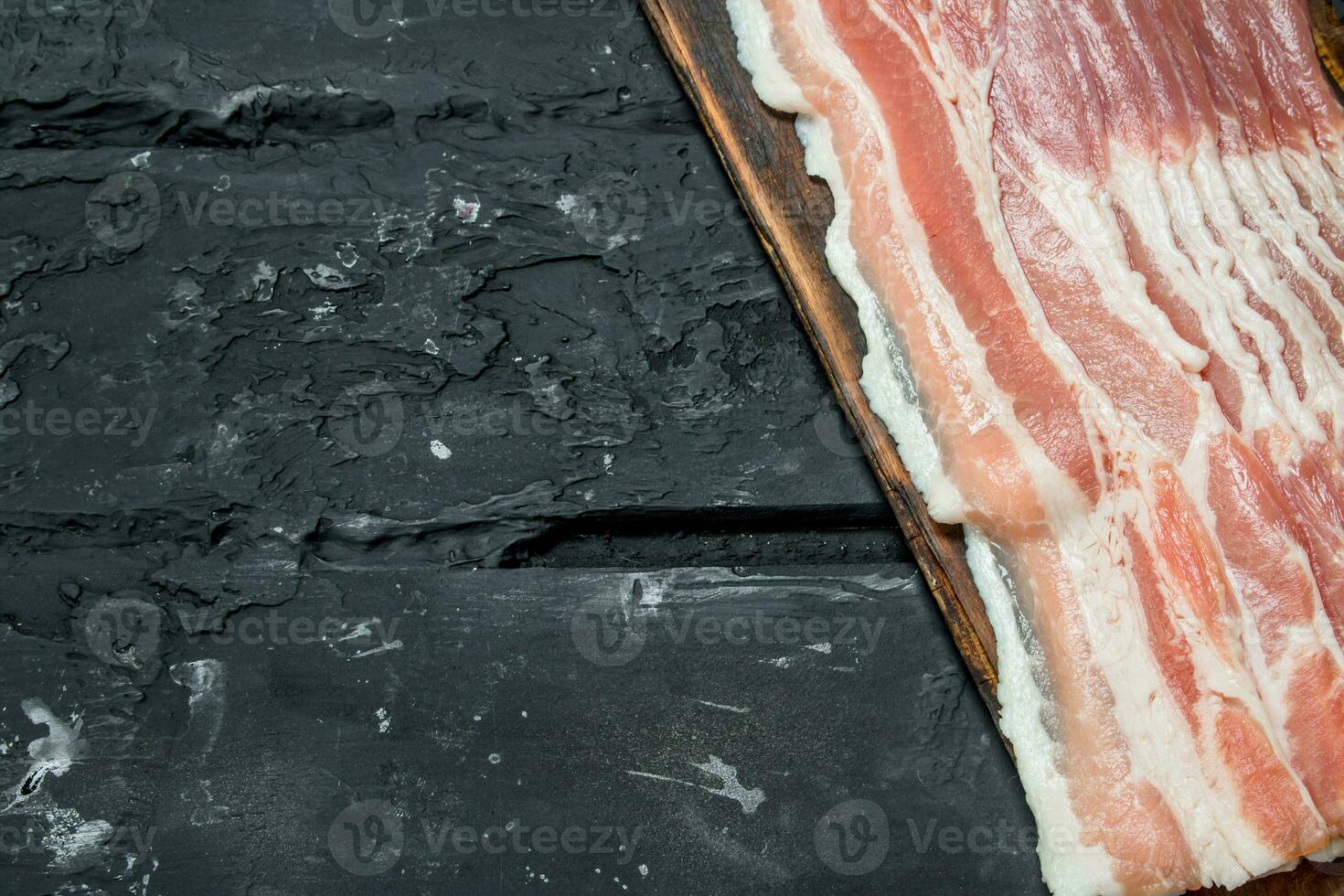 Raw bacon on a cutting Board. photo