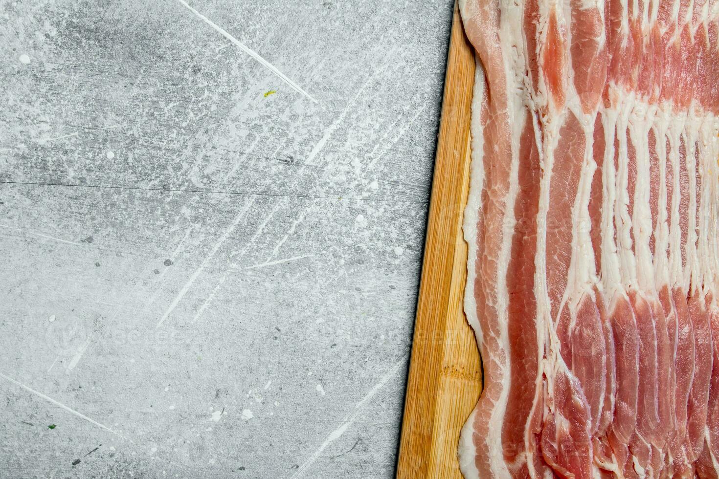 Raw bacon on the Board. photo