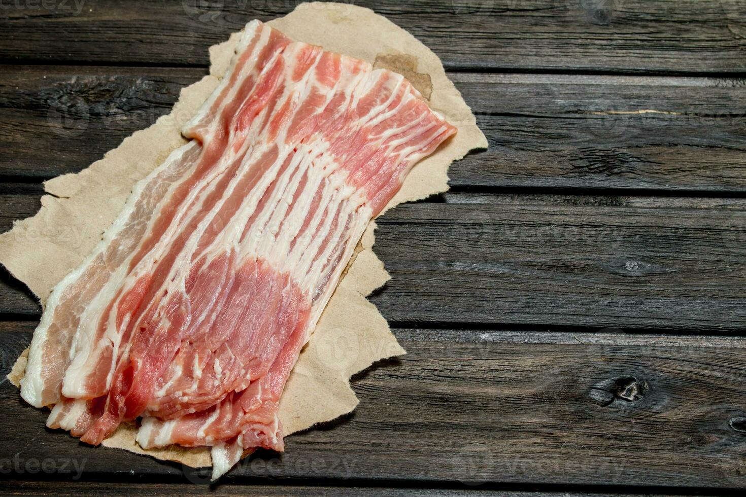 Raw bacon on paper. photo