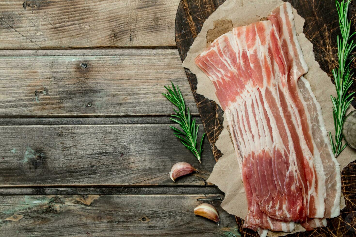 Raw bacon on paper. photo