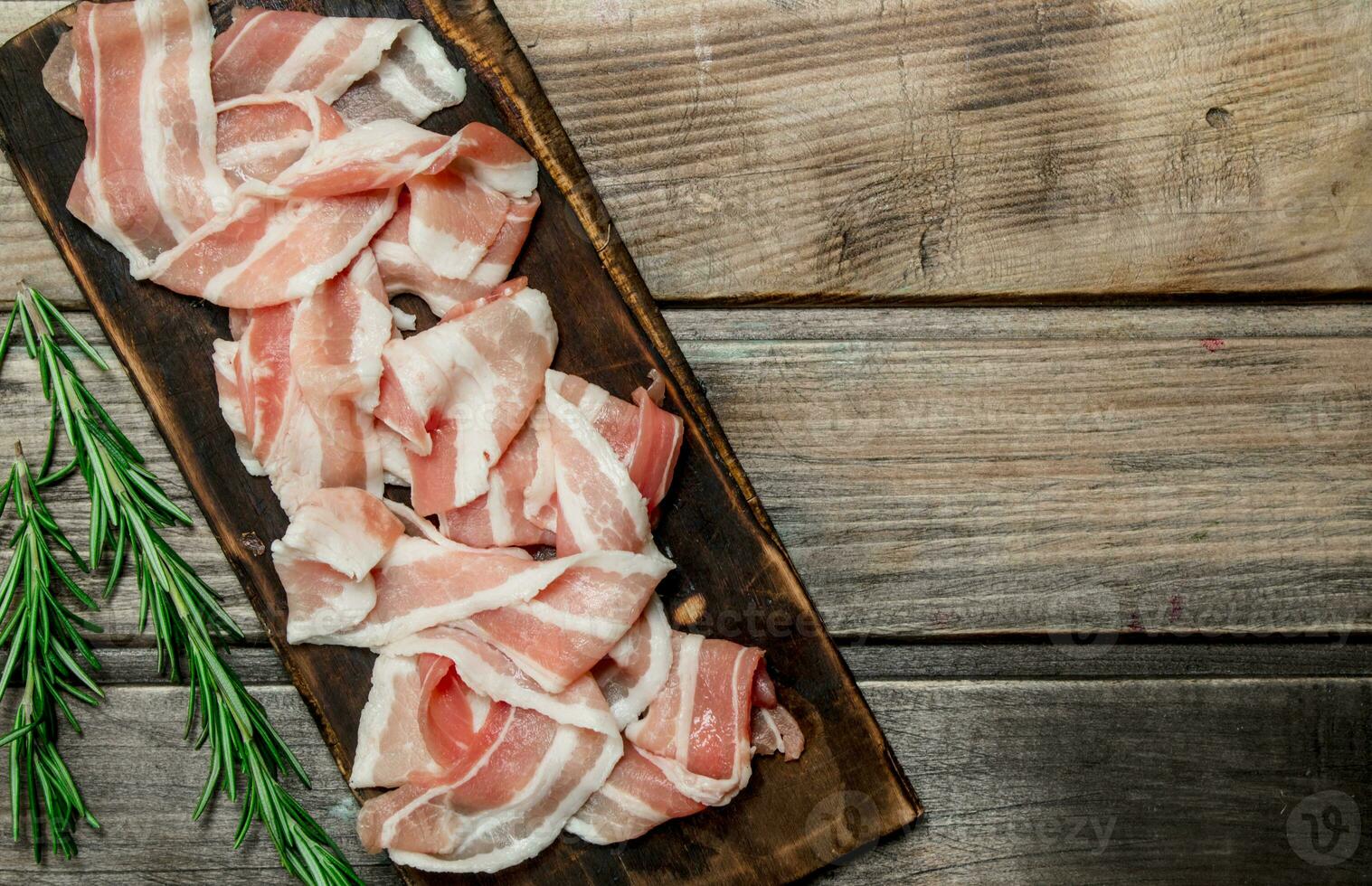 Raw bacon with fragrant rosemary. photo