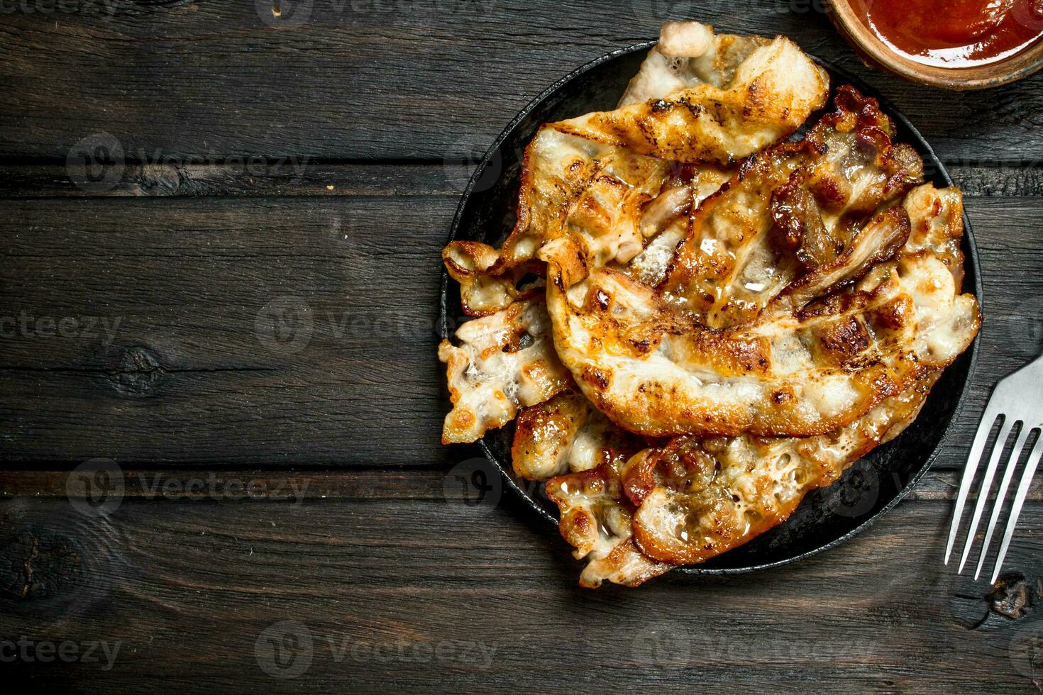 Fried bacon with tomato sauce. photo