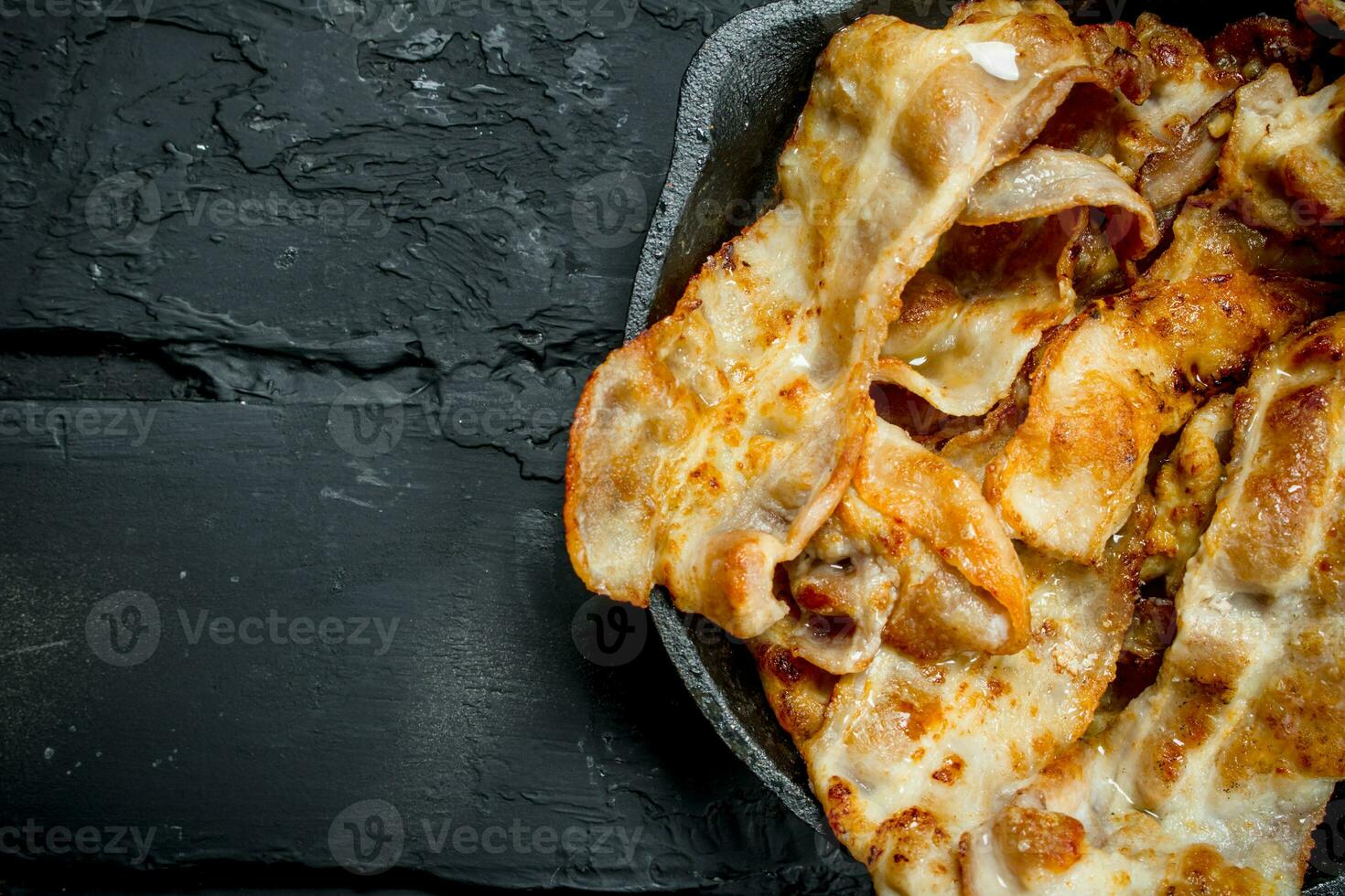 Fried bacon in a frying pan. photo