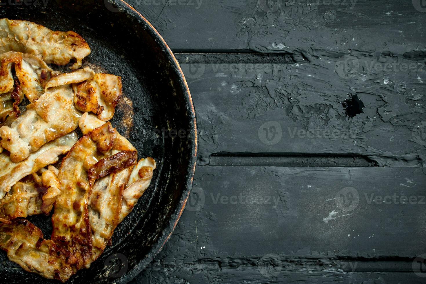 Fried bacon in a frying pan. photo