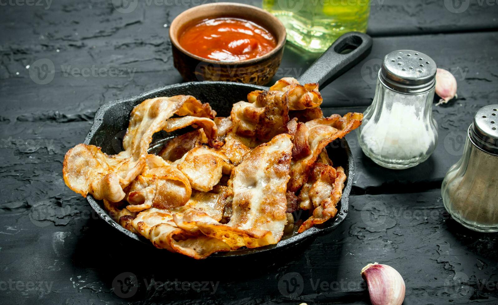 Fried bacon with tomato sauce. photo