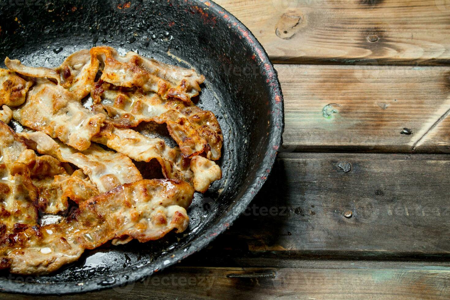 Fried bacon in a pan. photo