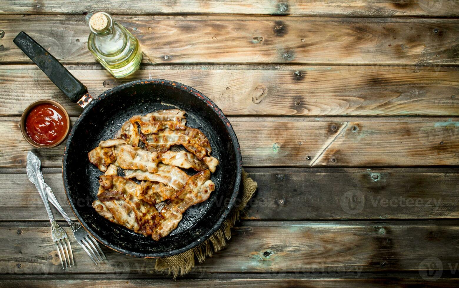 Fried bacon with tomato sauce. photo