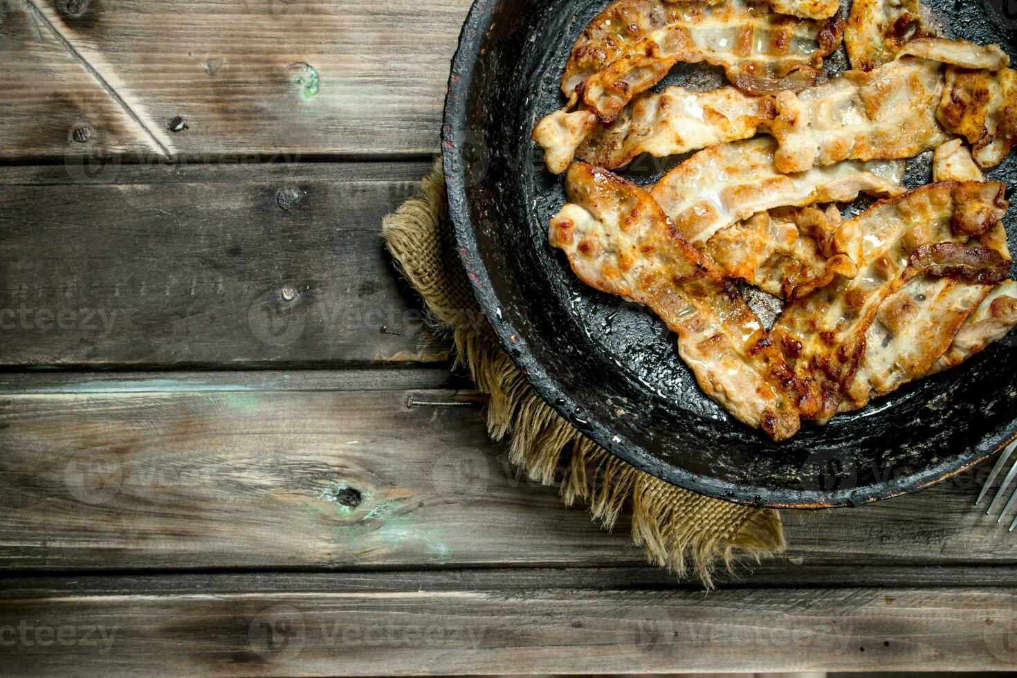 Fried bacon in a pan. photo