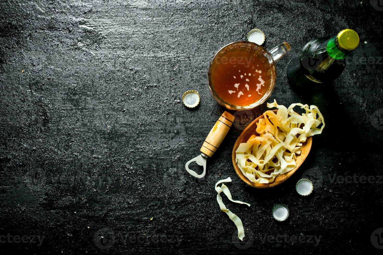 Beer in a glass mug and snacks in the bowl. photo
