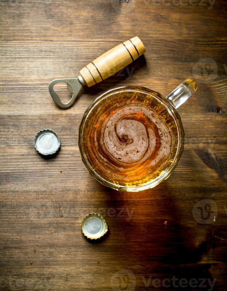 Beer in a mug with opener and covers. photo