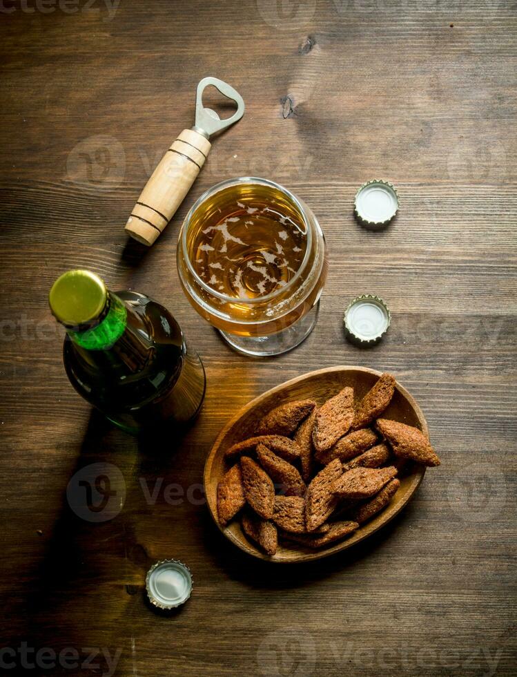 cerveza en un vaso y un botella de migas en un bol. foto