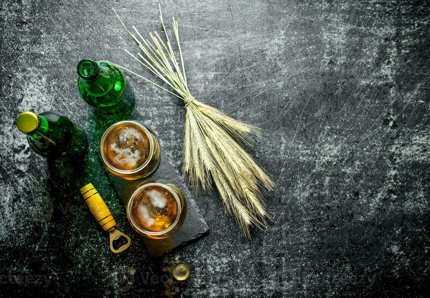 Beer in glasses and bottles with a bunch of spikelets. photo
