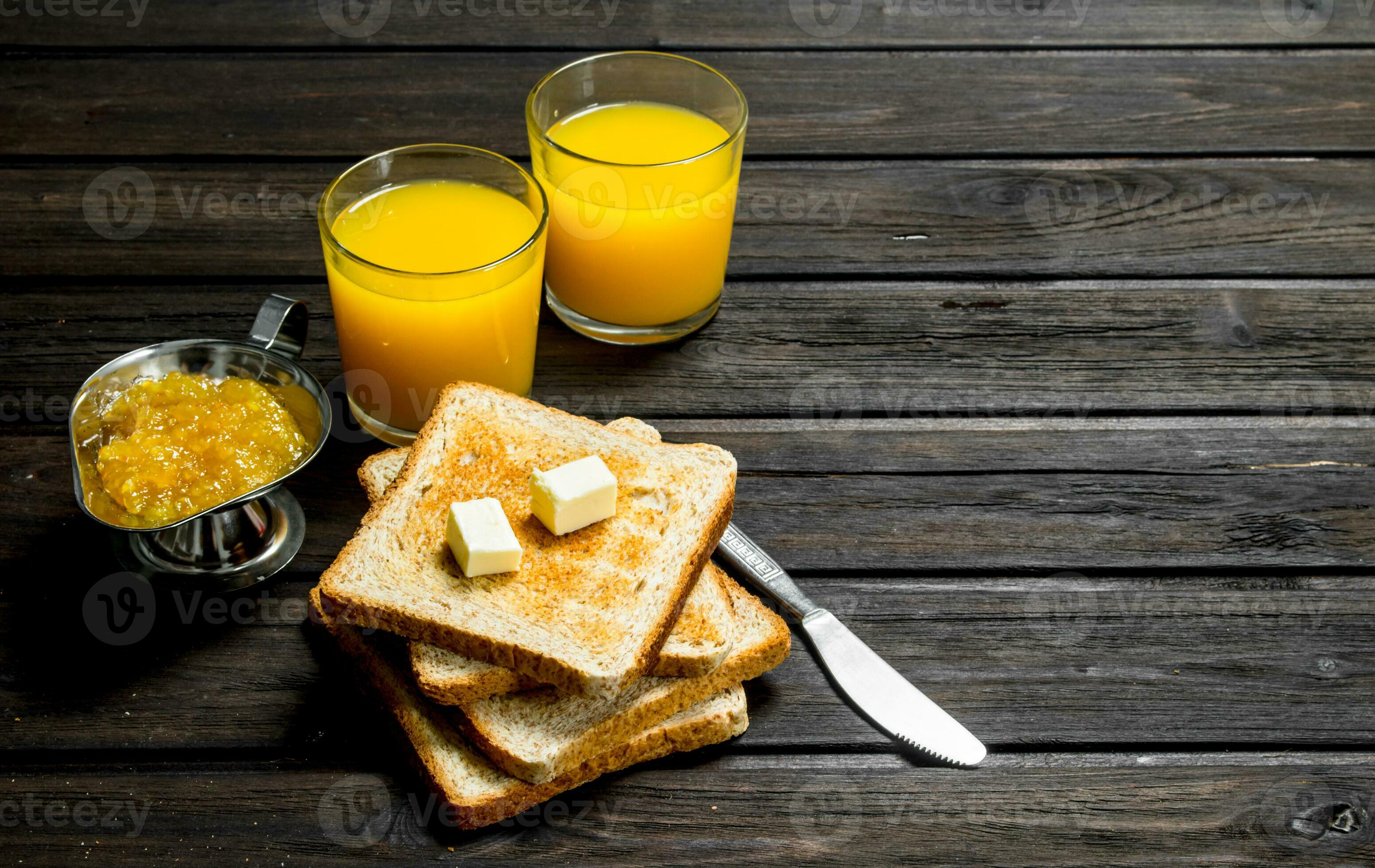 Toasted bread with butter, orange jam and juice. 32002019 Stock Photo
