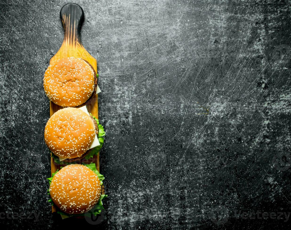 Burgers on a wooden stand. photo