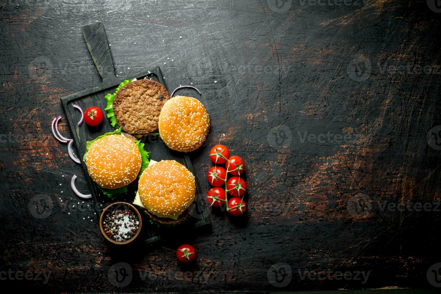Beef burgers and spices in bowl on cutting Board. photo