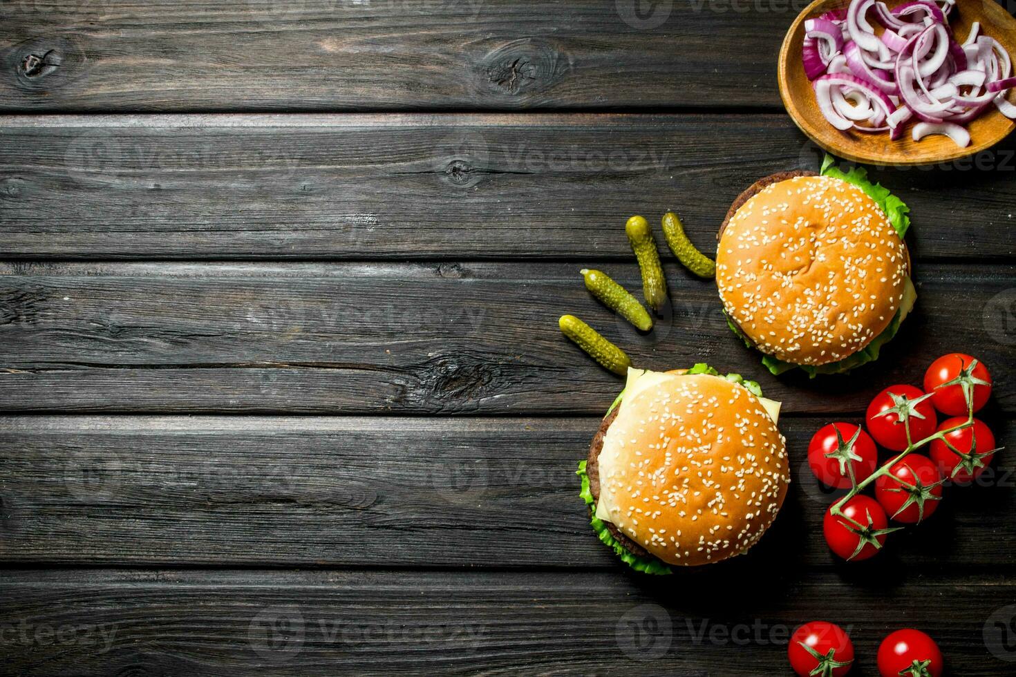 Burgers with tomatoes,cucumbers and onion slices in bowl. photo