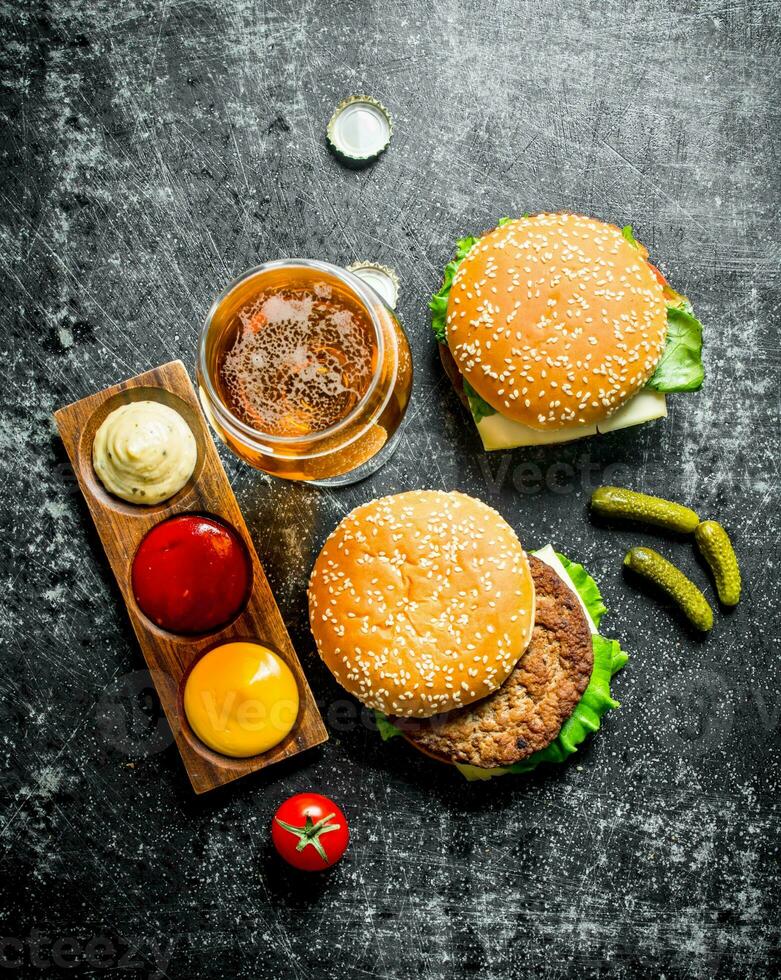 Burger with beer, sauces and gherkins. photo