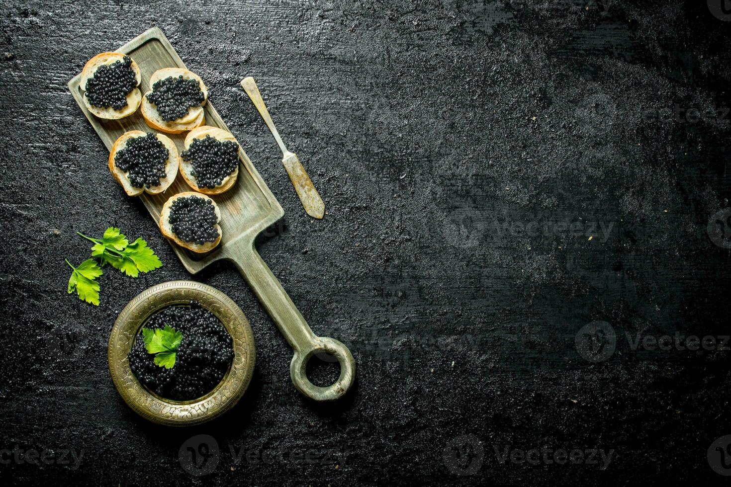 Sandwiches with black caviar on the cutting Board. photo