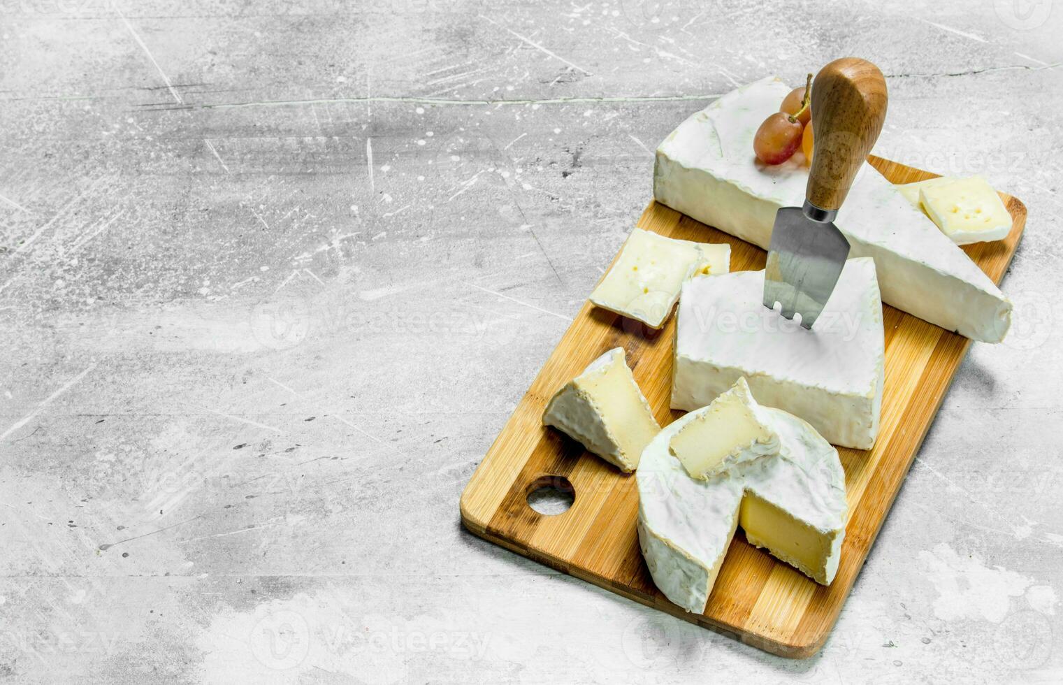 Brie cheese with grapes on a wooden Board. photo