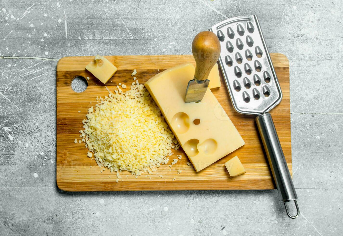 Fresh grated cheese on a chopping Board. photo