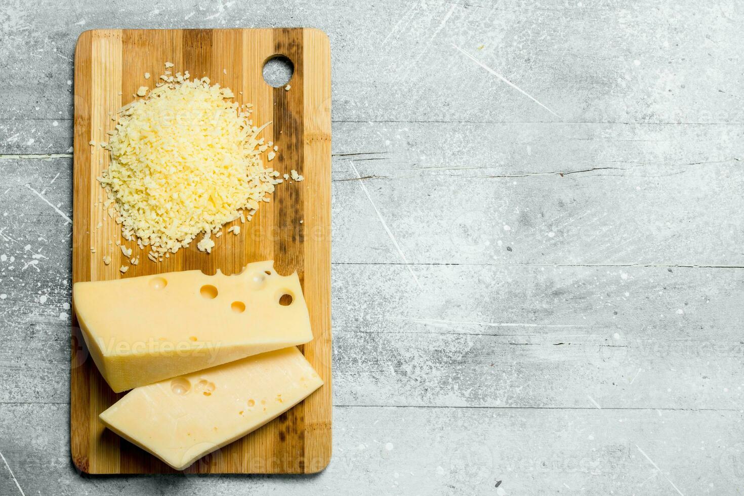 Fresh grated cheese on a wooden Board. photo