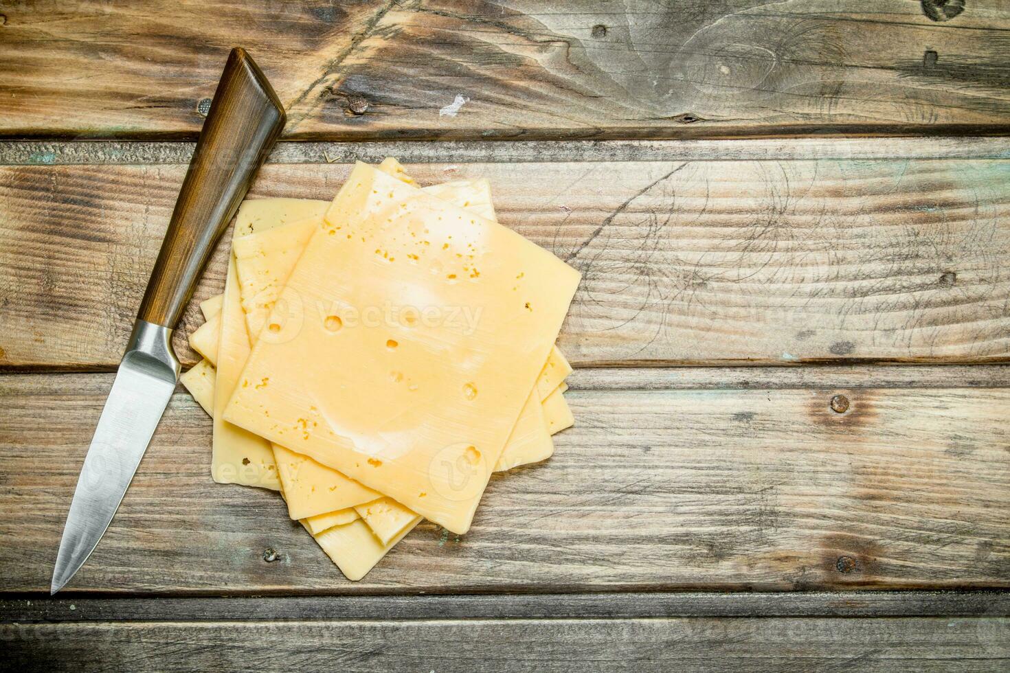 Thin slices of cheese with a knife. photo