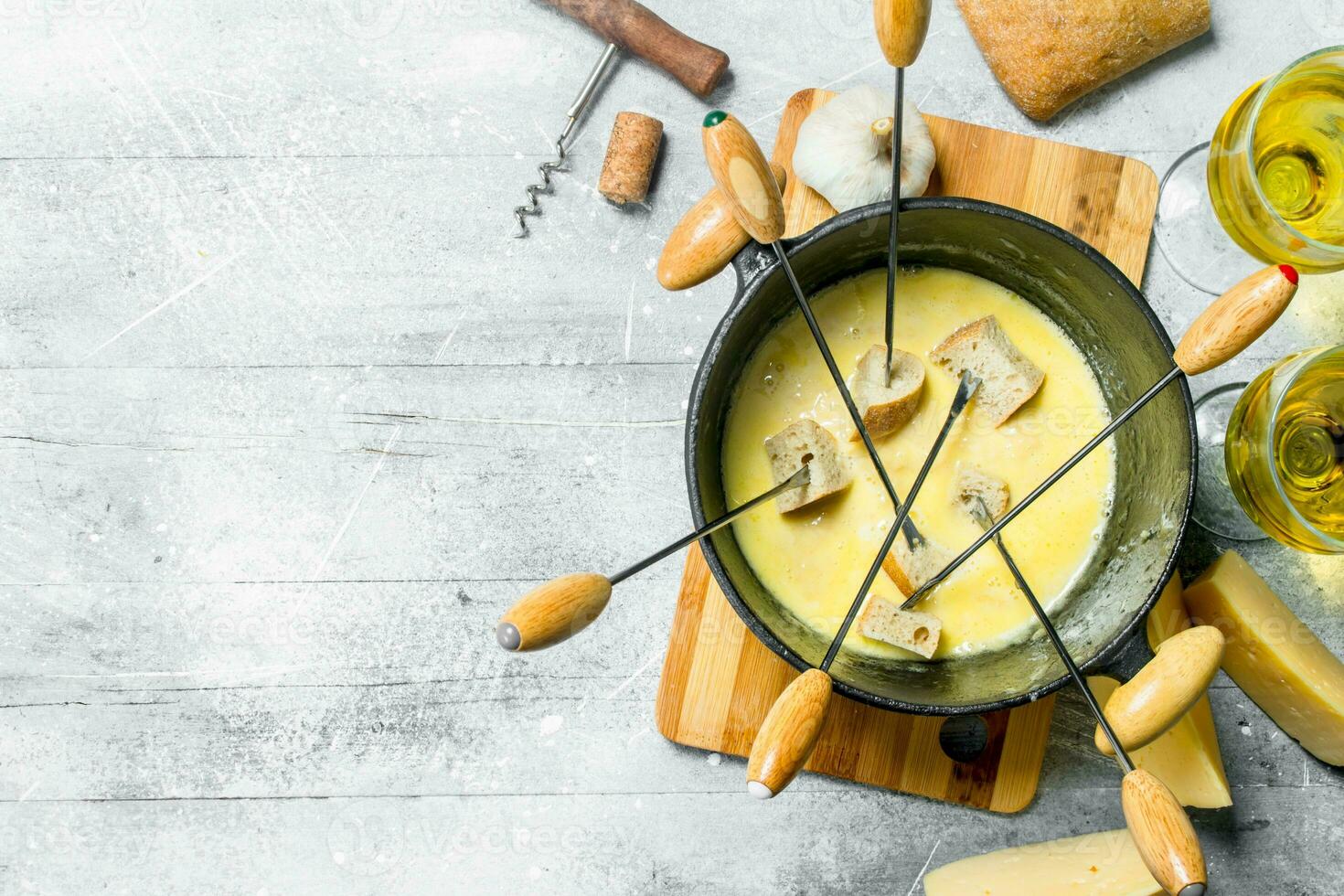 Delicious fondue cheese with bread and white wine photo