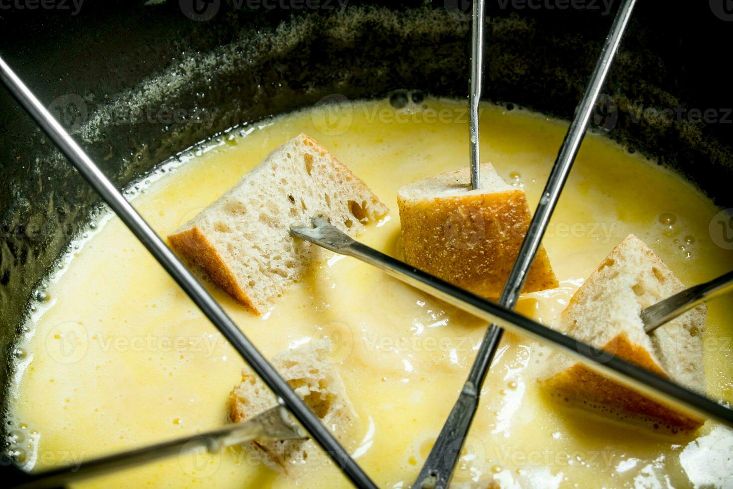 Delicious fondue cheese with slices of bread . photo