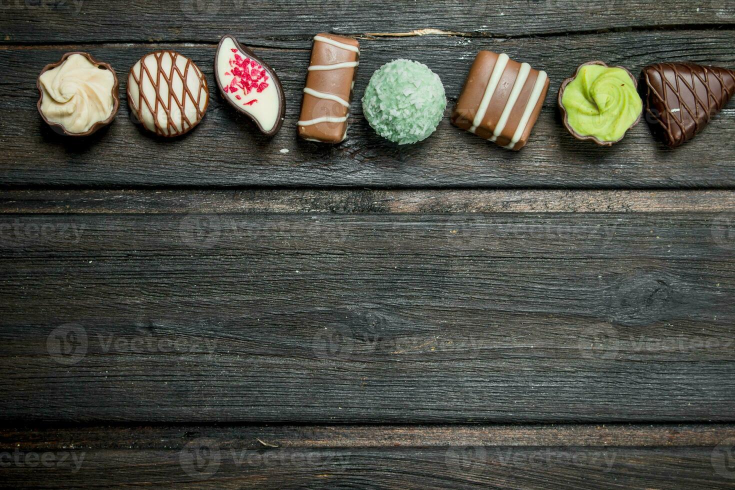 Chocolate sweets with nuts and various fillings. photo