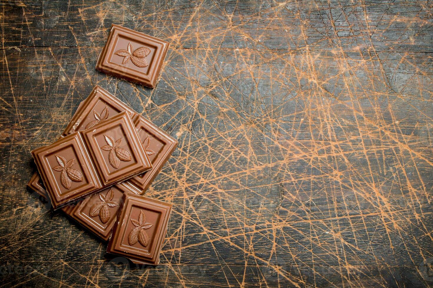 Chocolate wedges on wooden background. photo