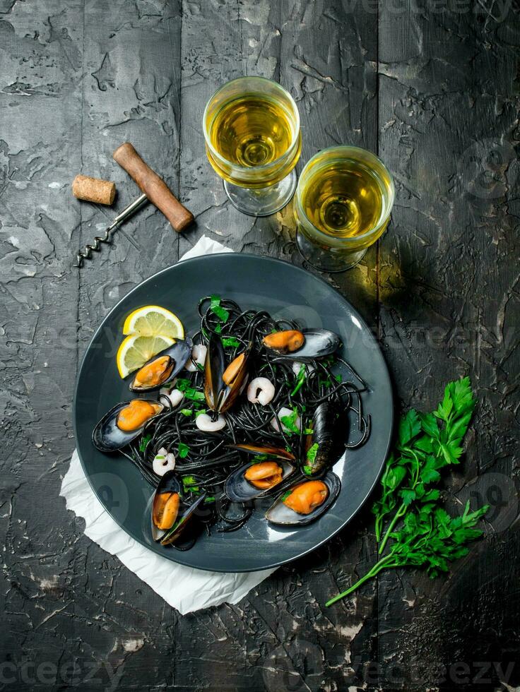 Mediterranean food. Spaghetti with cuttlefish ink, clams and white wine. photo