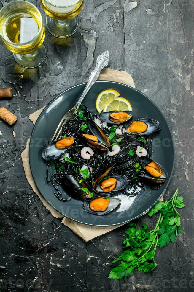 Mediterranean food. Spaghetti with cuttlefish ink, clams and white wine. photo