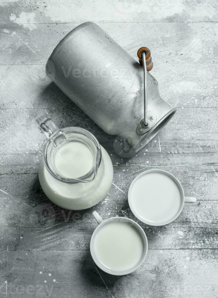 Milk in mugs with a can. photo