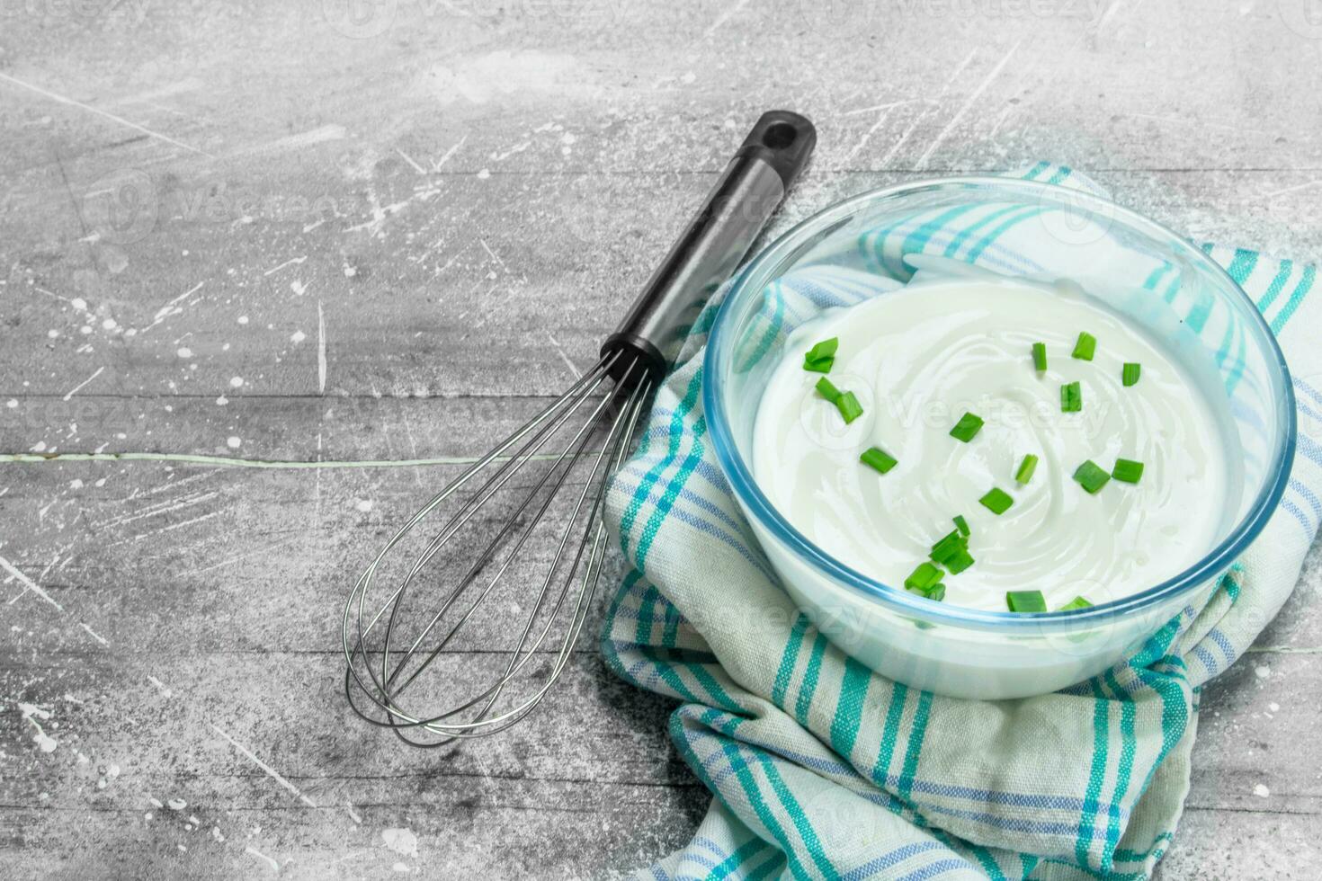 Sour cream in bowl with green onions. photo