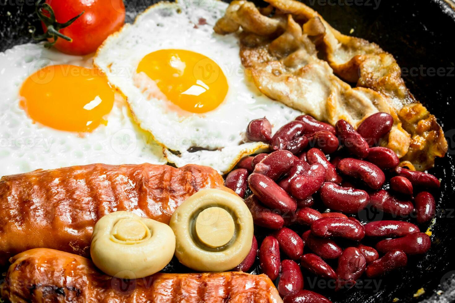 English breakfast.Fried eggs with sausages, mushrooms and beans. photo
