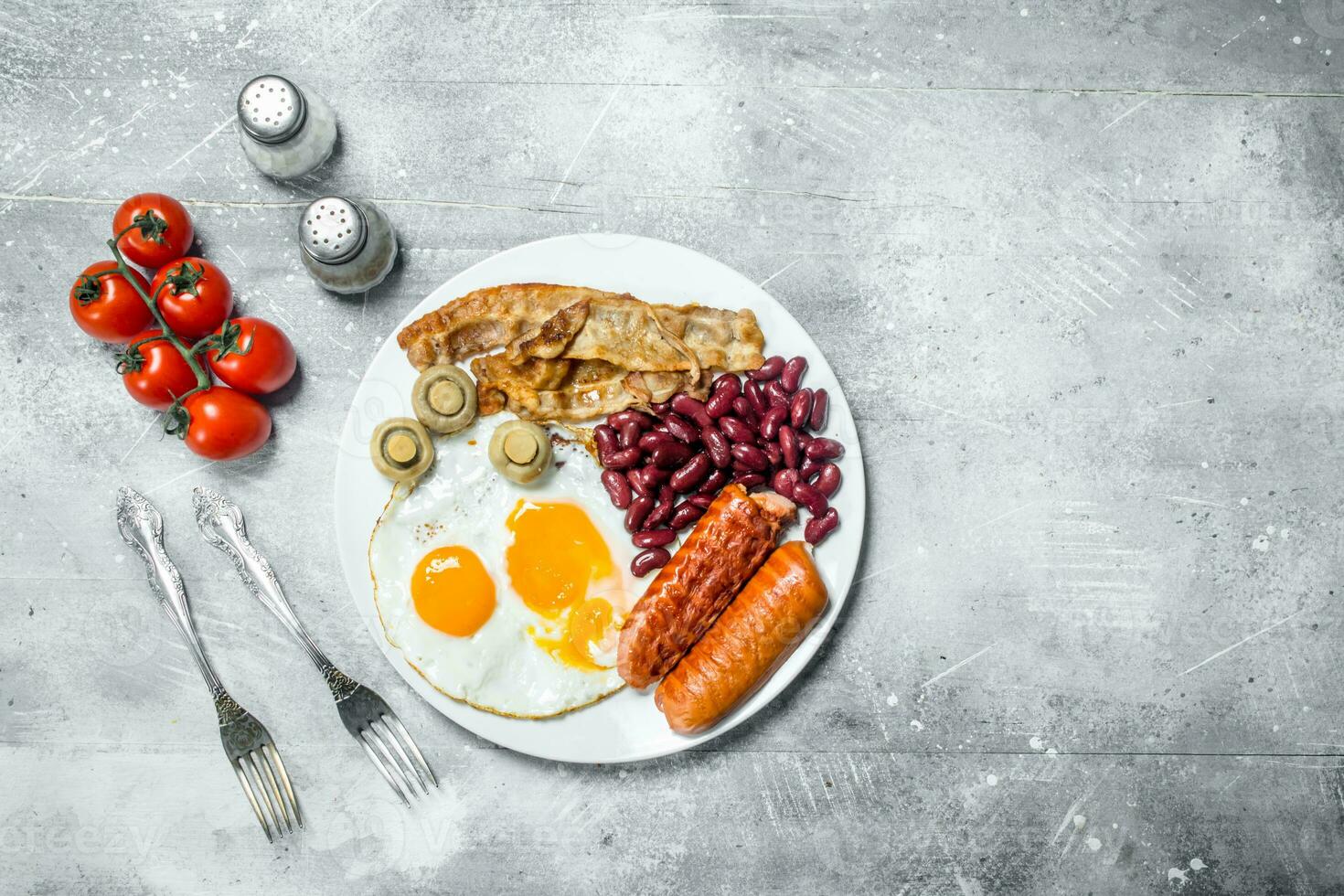English breakfast. Fried eggs with sausages, bacon and beans. photo