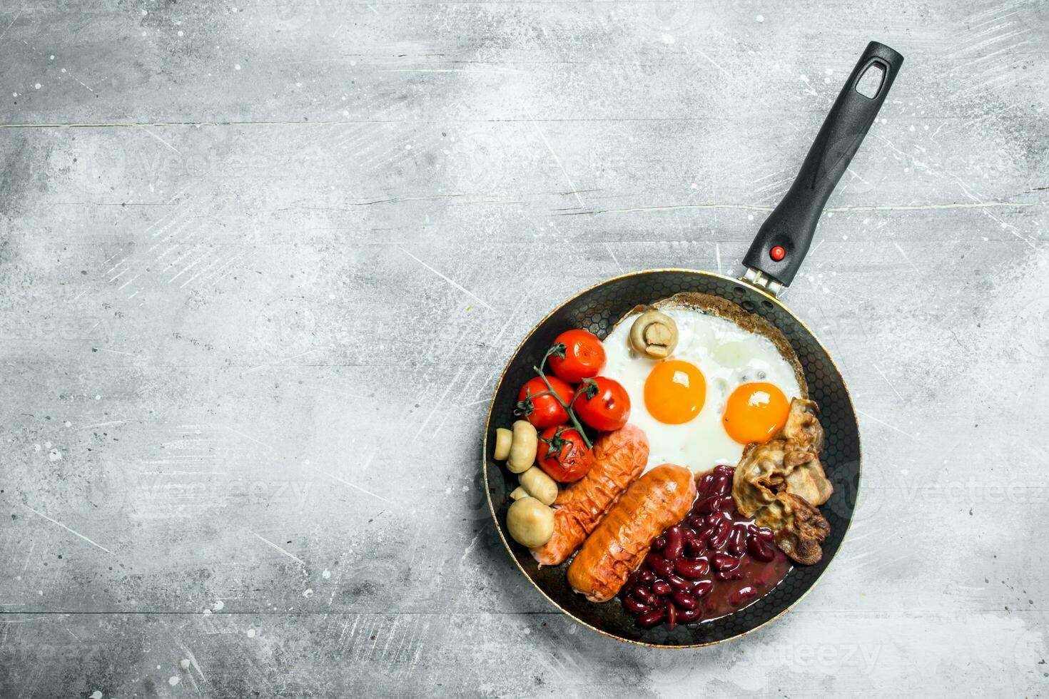 English breakfast. Fried eggs with sausages, bacon and beans. photo