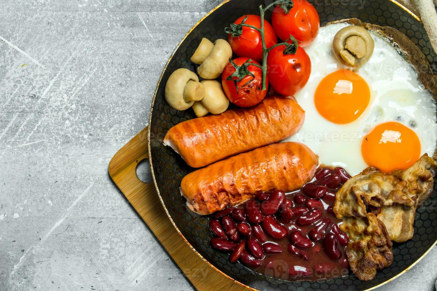 English breakfast. Fried eggs with sausages, bacon and beans. photo