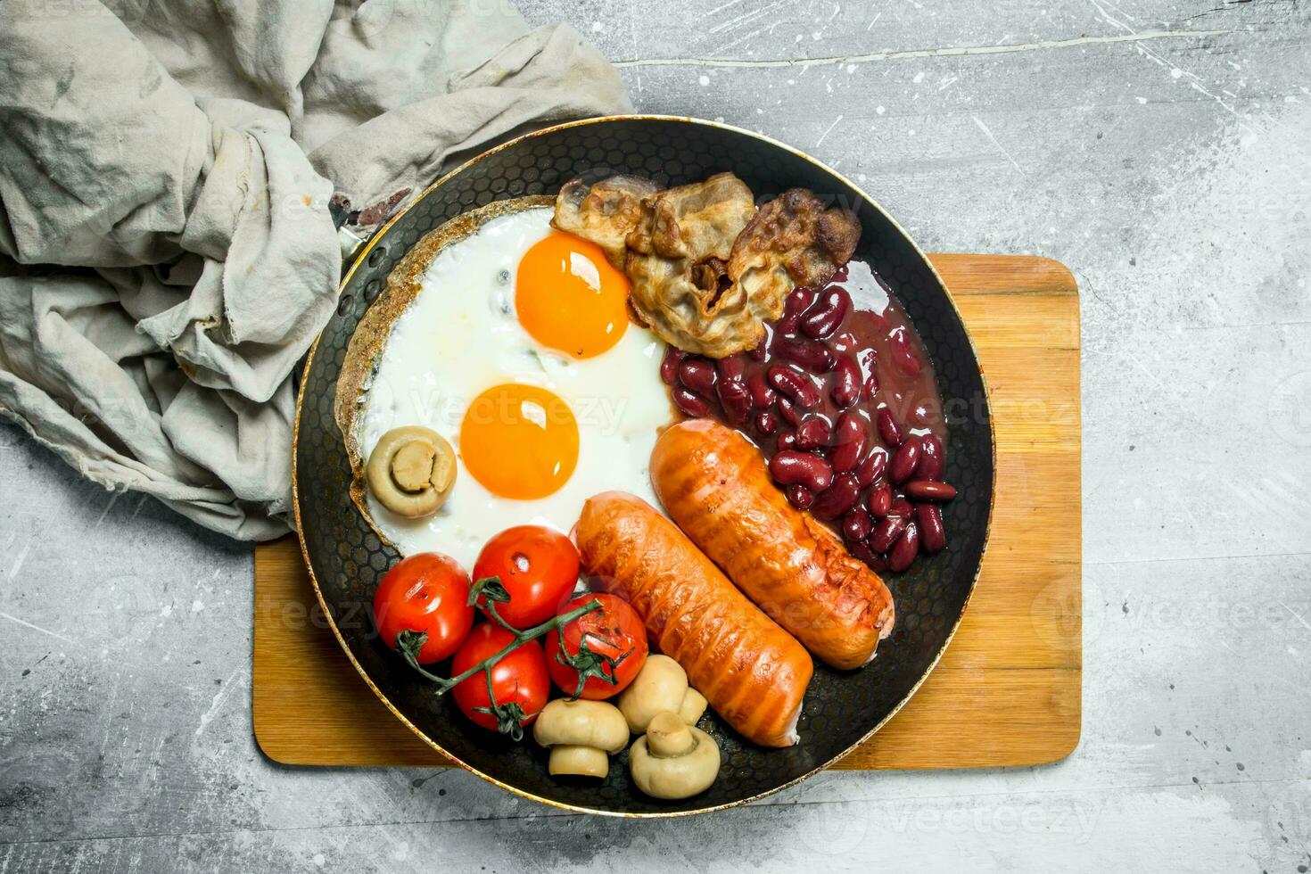 English breakfast. Fried eggs with sausages, bacon and beans. photo