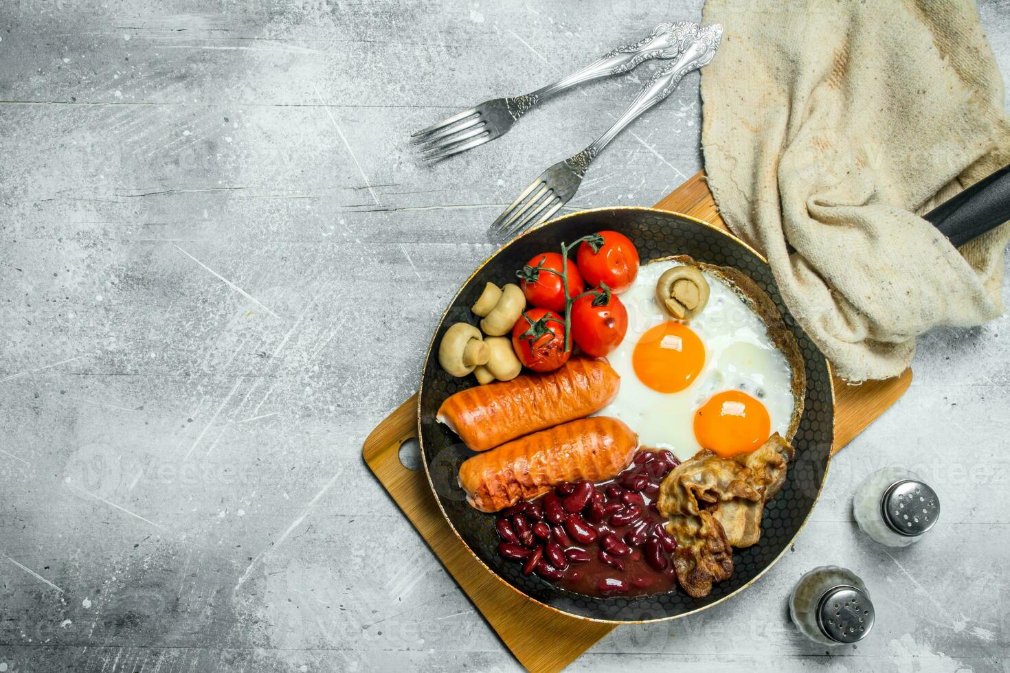 English breakfast. Fried eggs with sausages, bacon and beans. photo