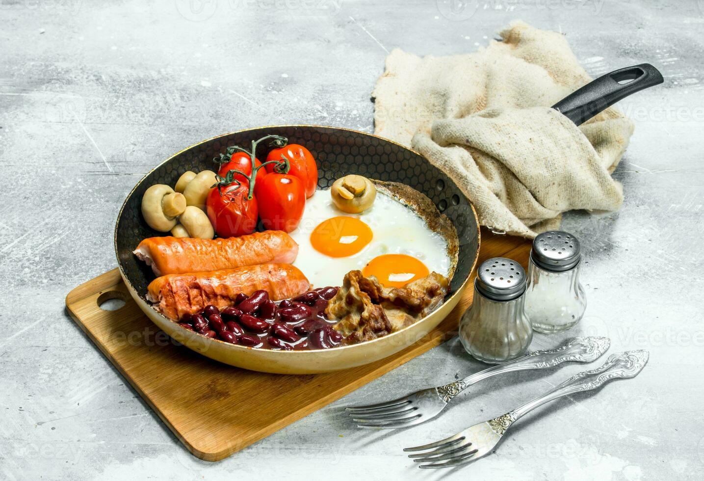 English breakfast. Fried eggs with sausages, bacon and beans. photo