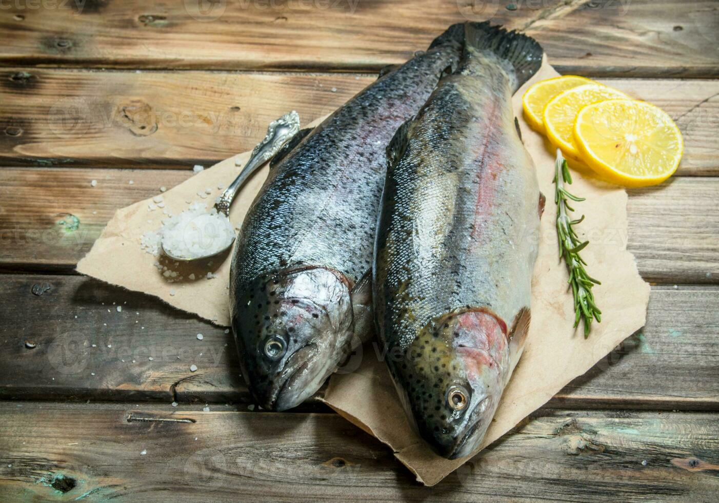 Raw sea fish with herbs and lemon wedges. photo