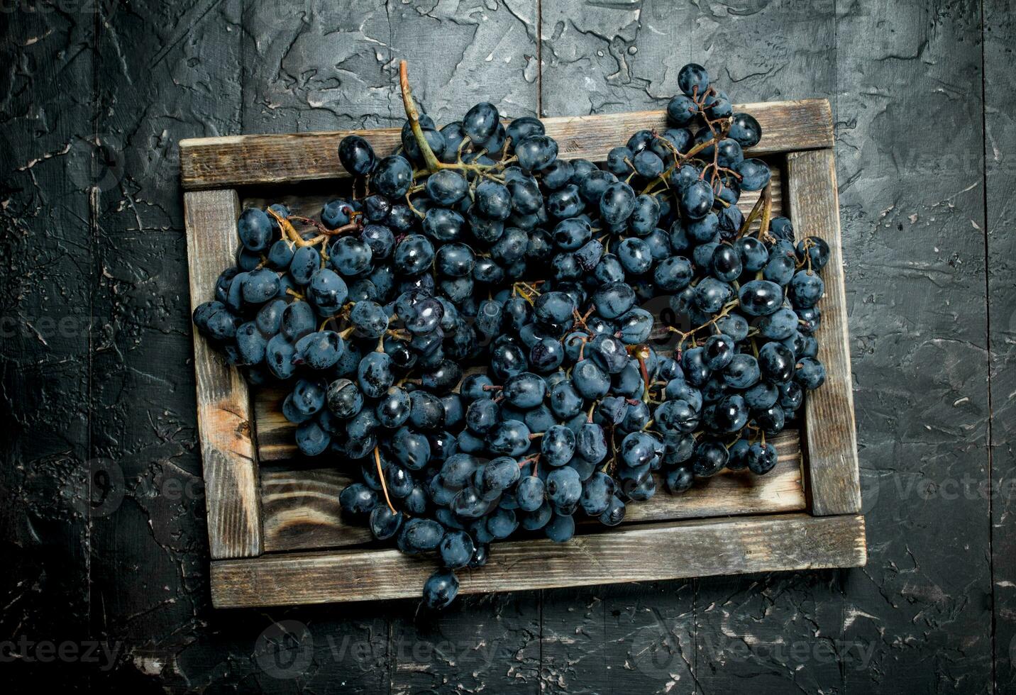 Black grapes on a wooden tray. photo