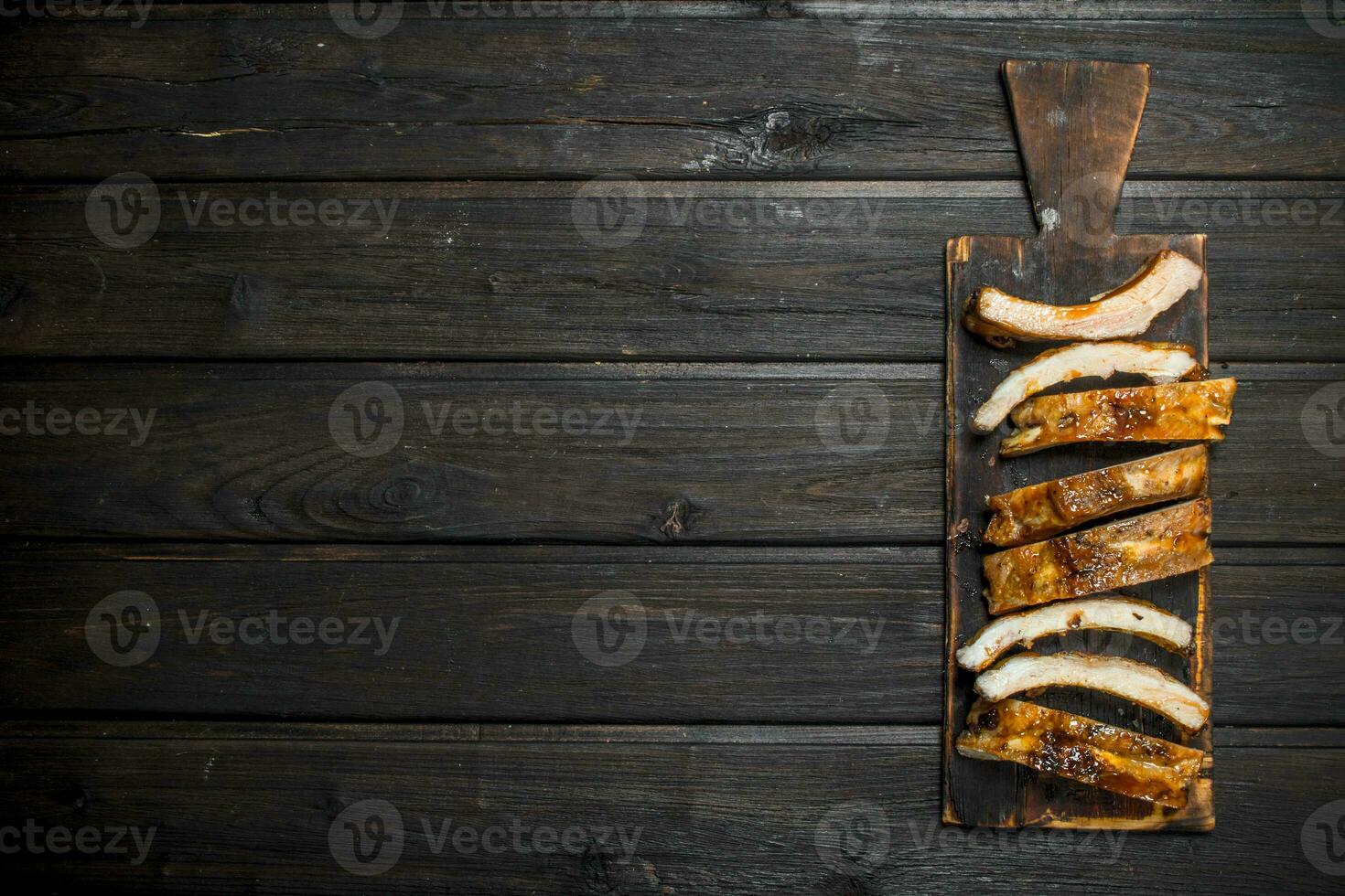 Sliced grilled ribs on an old Board. photo