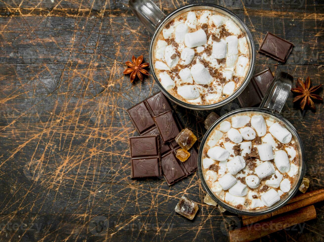 Hot chocolate in mugs with marshmallows and fragrant cinnamon. photo
