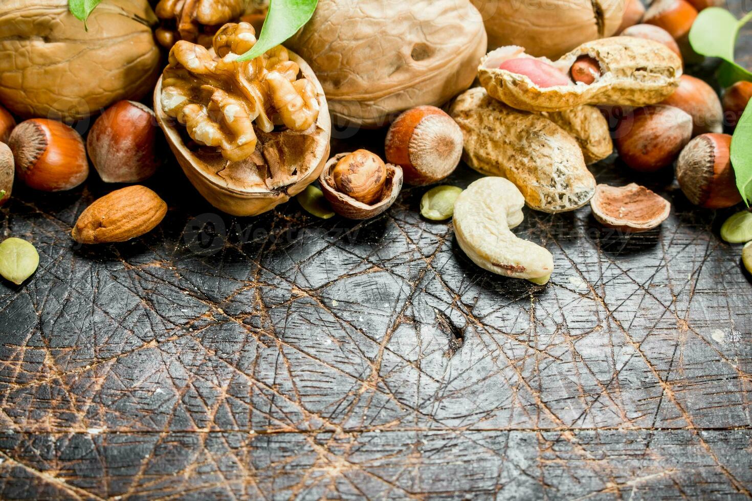 Nuts background. Different kind of nuts with green leaves. photo