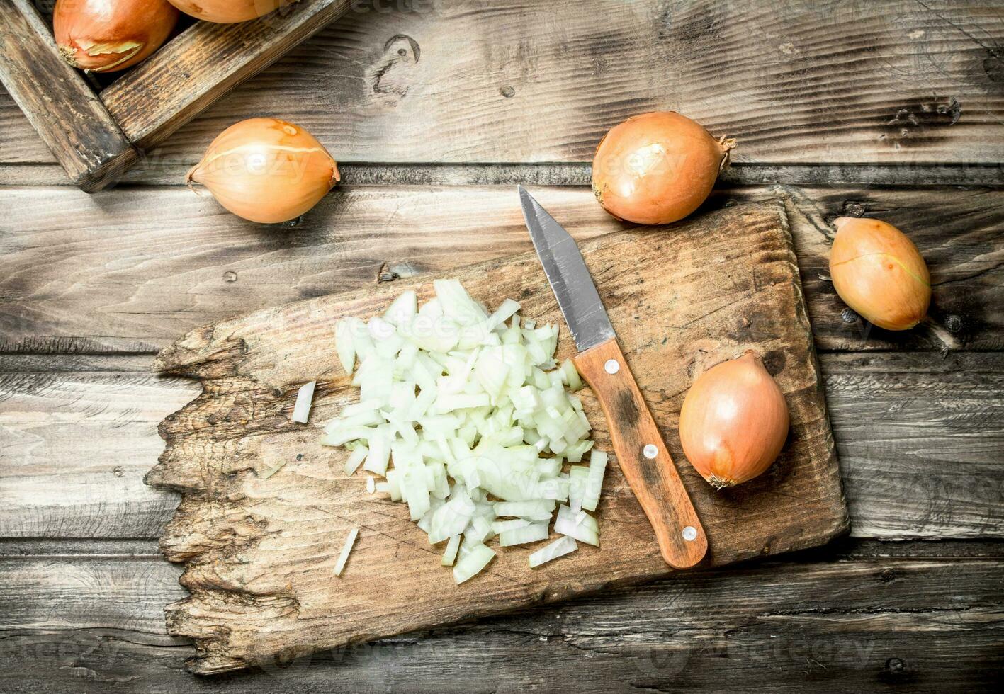 Finely chopped onion on a cutting Board with a knife. photo